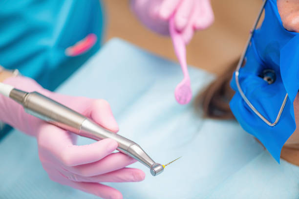 Root canal treatment. An endodontist preparing patient for root canal treatment.